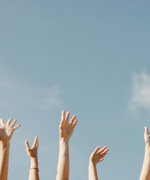 Person opening their arms in a gesture of welcome and freedom.