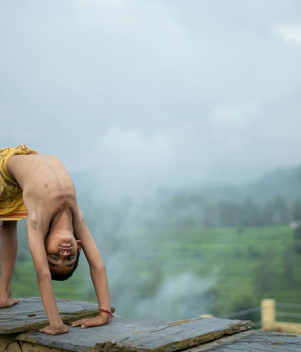 Woman in a graceful yoga pose against a misty white background.